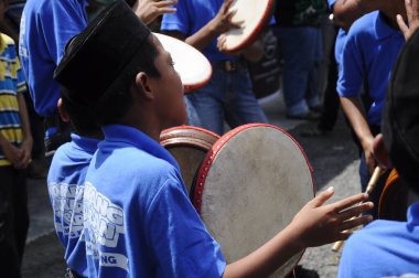 KUALA LUMPUR, MALAYSIA - 2 Mart 2019: Çocuk Malezya geleneksel düğün töreninde kompang oynuyor. Onlar kompang çalarken birlikte şarkılar söyleyecekler. Kompang geleneksel Malezya davuludur.. 