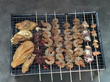 Barbekü, açık havada barbekü. Yeşil çimlerin arkasında ızgara tavuk bacağı. Üst görünüm