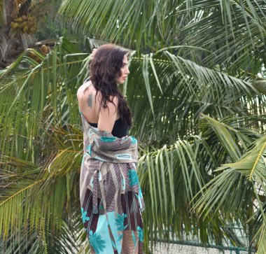 Parktaki genç model. Kahverengi ceketli kız. Sonbahar parkındaki kadın. Yapraklı kadın..