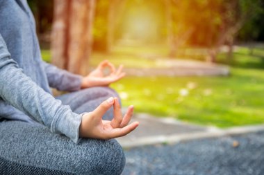 Genç yogacı kadın gün batımında okyanus sahilinde meditasyon yapıyor. Kadın Yoga - doğada rahatla.