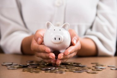 Para biriktirmek için domuzcuğa para koyan kadın eli. Gelecek plan ve emeklilik fonu kavramı için para biriktirme.