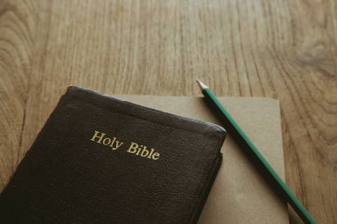 Kutsal İncil, defter ve kalemle ahşap masada, boşluğu kopyala.
