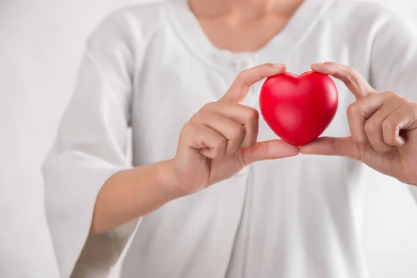 Woman holding red heart symbol of World heart day. White background isolated.