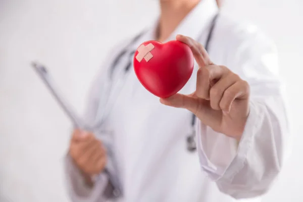 Woman holding red heart symbol of World heart day. White background isolated.