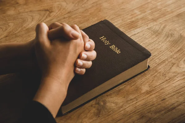 Woman Bible Praying Hands Clasped Together Her Bible Wooden Table — Stock Photo, Image