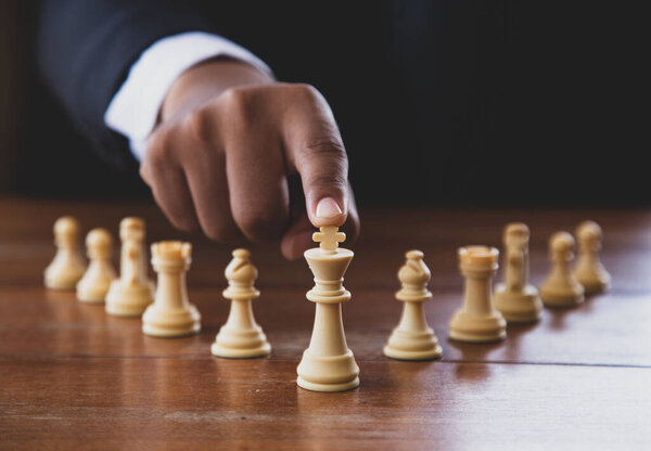 Рука бизнесмена, движущегося шахматной фигурой в игре успеха соревнования. стратегия, тонизированный ретро эффект.