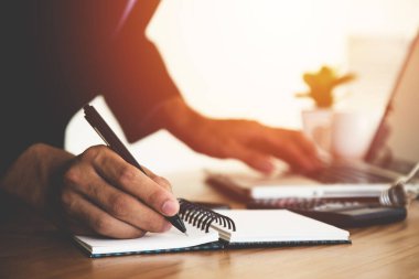 Ofiste dizüstü bilgisayarla çalışan bir iş adamı, iş adamının elini kapatır.. 