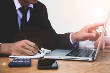 Ofiste dizüstü bilgisayarla çalışan bir iş adamı, iş adamının elini kapatır.. 