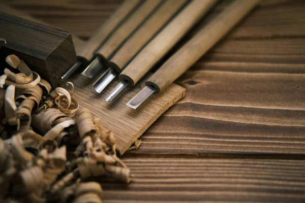 Close up view of a set of wood chisels for carving wood, sculpture tools on wooden background — Stock Photo, Image