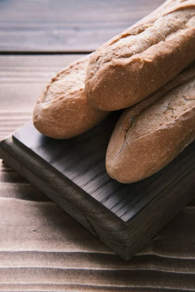 Feche o tiro de uma baguete francesa fresca na tábua de madeira. pronto para comer — Fotografia de Stock