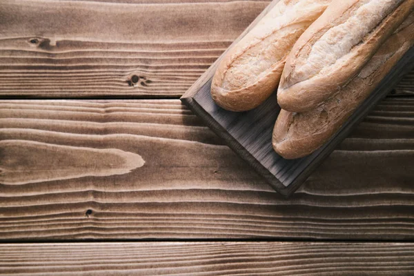 Baguete francesa fresca em tábua de madeira. pronto para comer — Fotografia de Stock