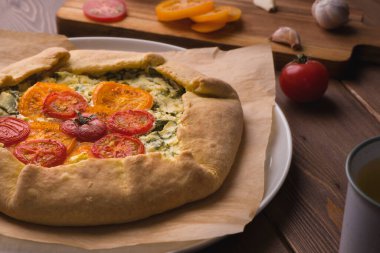 Tahta arka planda domatesli, peynirli ve otlu vejetaryen pizza. Kırsal tarzda. Metin için yer