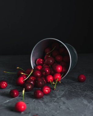 Arka planda bir kovadan dökülen kirazlar. Yaz. Metin için yer.