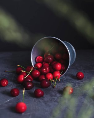 Arka planda bir kovadan dökülen kirazlar. Sonraki yer