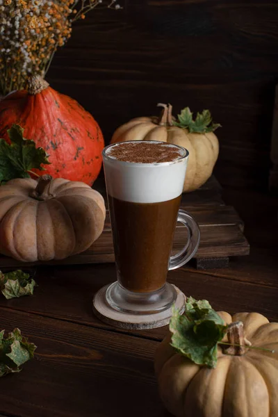 Pumpkin latte. Pumpkins on a wooden background in rustic style