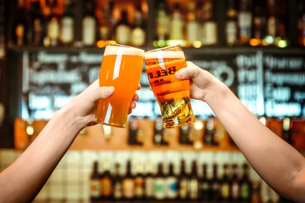 Zwei Freunde stoßen in der Kneipe mit einem Glas Leichtbier an. schöner Hintergrund des Oktoberfestes. Feinkorn — Stockfoto