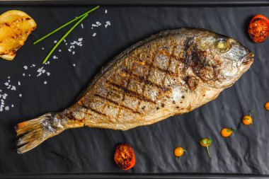 Lezzetli balık sebze ve limon siyah plaka üzerinde