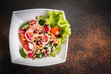 Taze ahşap arka plan üzerinde kase karışık yeşillik salatası.