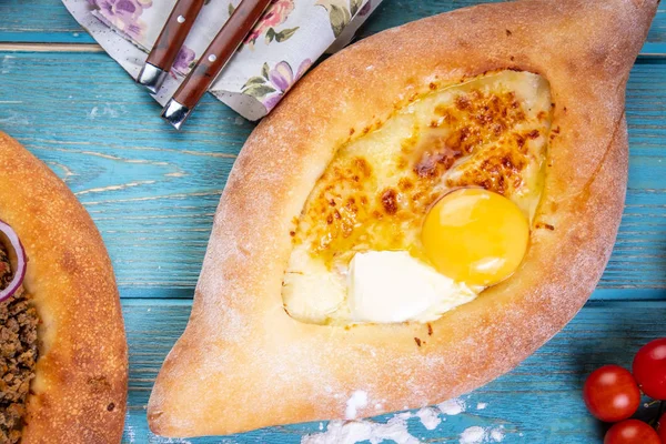 Tradicional georgiano adjara khachapuri y Kolkh khachapuri en la mesa azul . — Foto de Stock