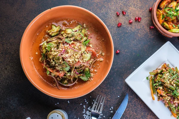 Ensalada saludable con espinacas, rúcula, cebolla roja y granada en plato sobre fondo de hormigón oscuro. Copiar espacio — Foto de Stock
