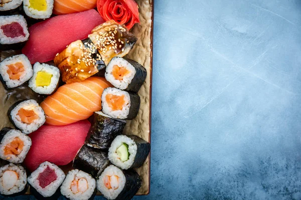 Conjunto de sushi y maki sobre mesa de piedra. Vista superior con espacio de copia — Foto de Stock
