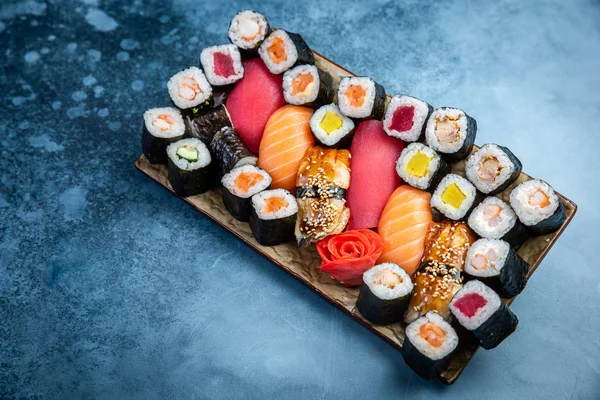 Conjunto de sushi y maki sobre mesa de piedra. Vista superior con espacio de copia — Foto de Stock