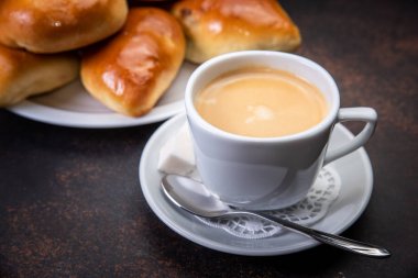 Kahve fincanı beyaz karanlık retro arka plan, seçici odak üzerinde ay çöreği. Kahvaltı konsepti