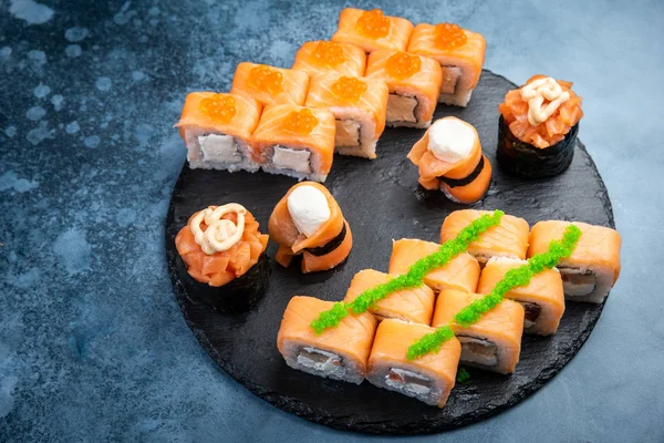 Rollos de sushi de salmón en tablero de servir redondo — Foto de Stock