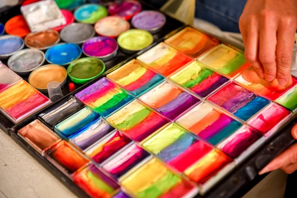 Colorful paint tubes on a table with paints used for face art