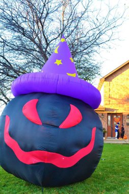 Şeytani palyaço gülüşlü şişme bebek ve Cadılar Bayramı 'nda Amerikan bahçesinin süsü olarak ay ve yıldızlı bir şapka.