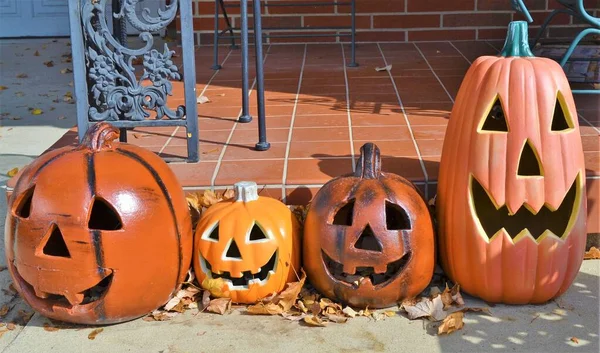 ハロウィンのアメリカの家の裏庭に刻まれた伝統的なものを模倣する4つの偽のカボチャ — ストック写真