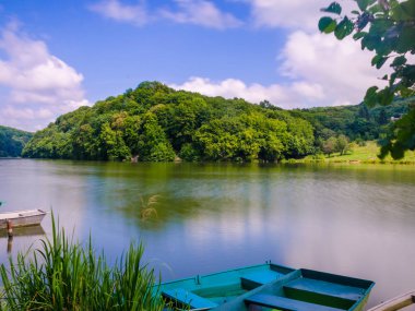 Ahşap iskele veya İskelesi ve göl günbatımı ve gökyüzü su yansıma bir teknede.