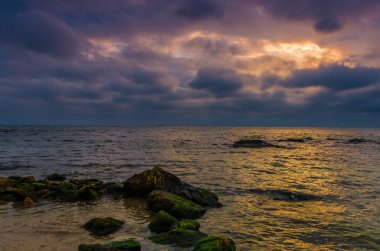 Taşlar ile deniz sahilde günbatımı