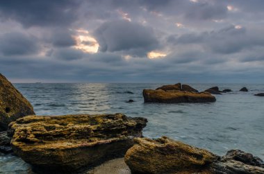 Taşlar ile deniz sahilde günbatımı