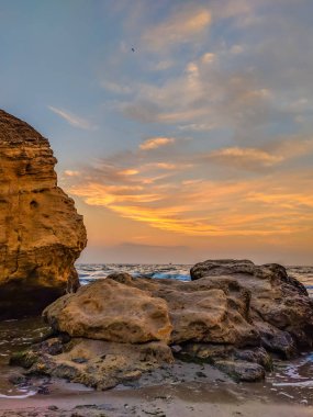 Taşlar ile deniz sahilde günbatımı