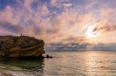 Taşlar ile deniz sahilde günbatımı