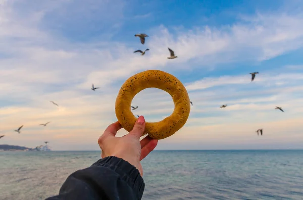 Deniz arka planda simit tutan kız