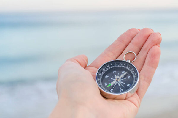Girl holding a comass on the Odesa sea background