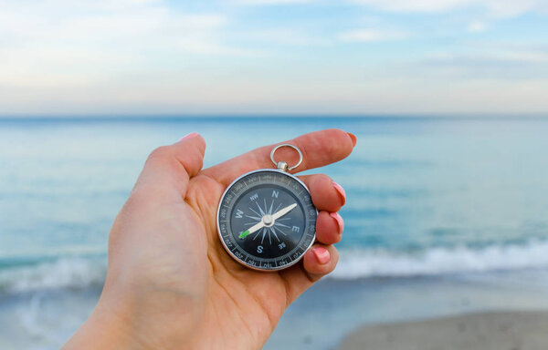 Girl holding a comass on the Odesa sea background