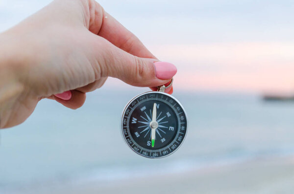 Girl holding a comass on the Odesa sea background
