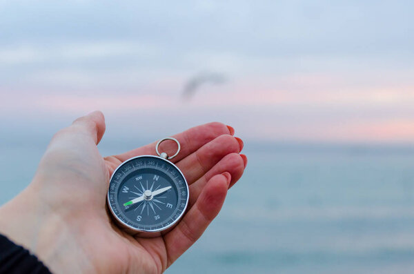 Girl holding a comass on the Odesa sea background