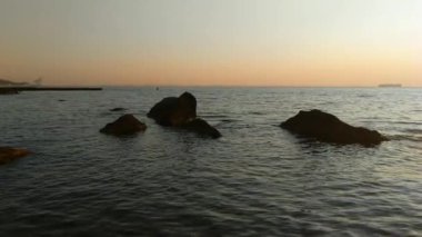 Taşlar ile deniz sahilde günbatımı