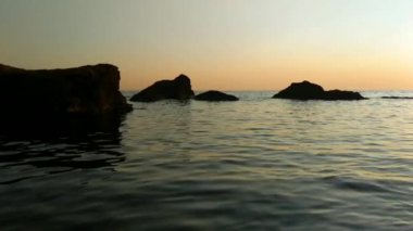 Taşlar ile deniz sahilde günbatımı