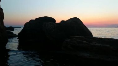 Taşlar ile deniz sahilde günbatımı