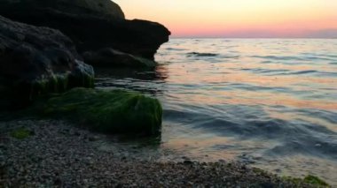 Taşlar ile deniz sahilde günbatımı