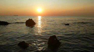 Taşlar ile deniz sahilde günbatımı