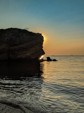 Yaz sezonunda gün batımında taşlarla deniz