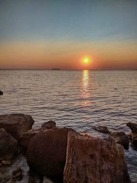 Yaz sezonunda gün batımında taşlarla deniz
