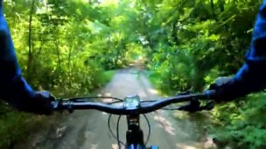 Yaz parkında bisiklet süren amatör bir binici.