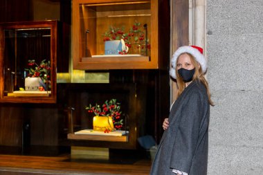 Noel sokaklara dökülür, hediyeler, alışveriş çantaları ve Noel süsleriyle genç bir kadın.
